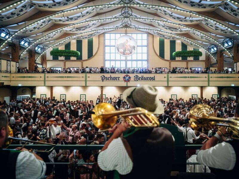 Muzikanten met trombones spelen boven de menigte in de feesttent Pschorr-Bräurosl op het Oktoberfest in München