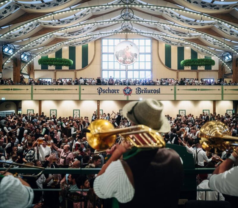 Muzikanten met trombones spelen boven de menigte in de feesttent Pschorr-Bräurosl op het Oktoberfest in München