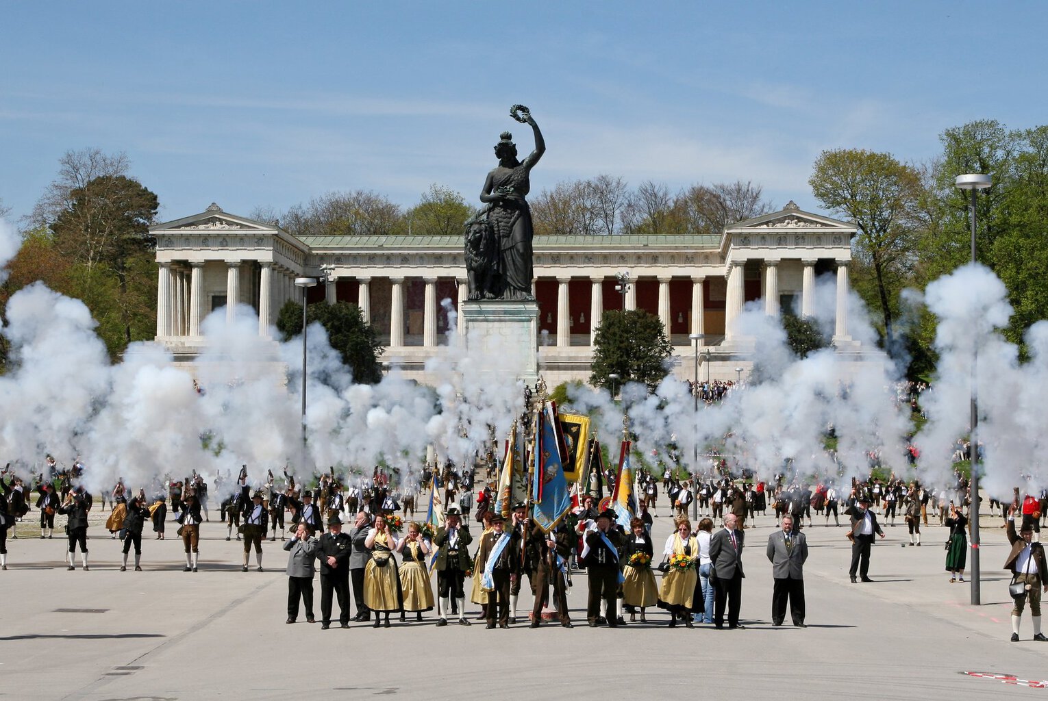 Schutters in klederdracht vuren saluutschoten af voor het Bavaria-beeld en de Ruhmeshalle op de Theresienwiese in München