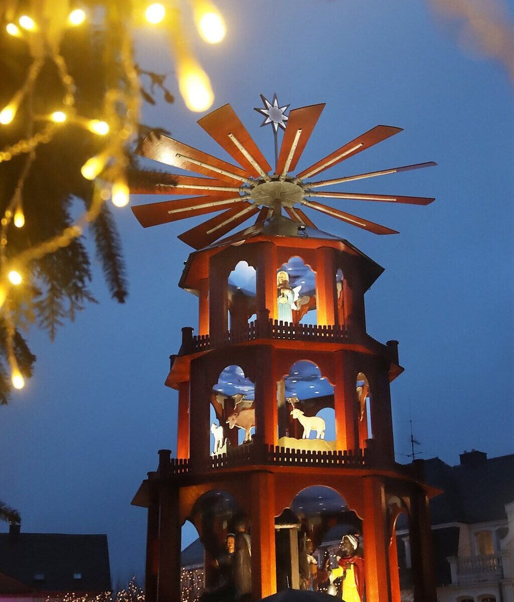 Verlichte houten kerstpiramide met kerstfiguren in het blauwe avondlicht op de kerstmarkt van St. Wendel