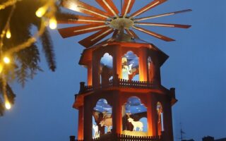 Verlichte houten kerstpiramide met kerstfiguren in het blauwe avondlicht op de kerstmarkt van St. Wendel