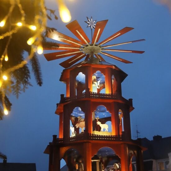 Verlichte houten kerstpiramide met kerstfiguren in het blauwe avondlicht op de kerstmarkt van St. Wendel
