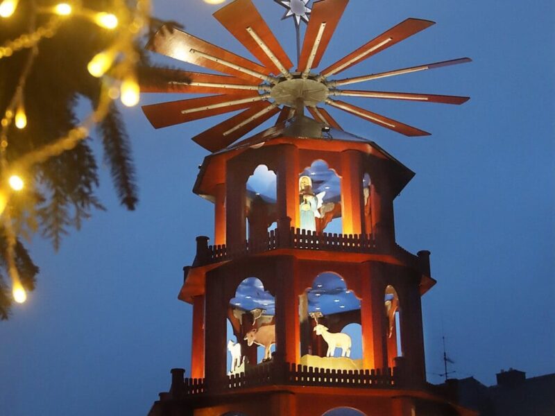 Verlichte houten kerstpiramide met kerstfiguren in het blauwe avondlicht op de kerstmarkt van St. Wendel