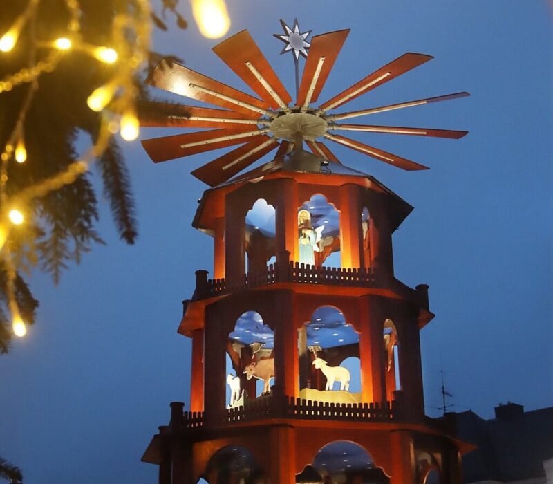 Verlichte houten kerstpiramide met kerstfiguren in het blauwe avondlicht op de kerstmarkt van St. Wendel