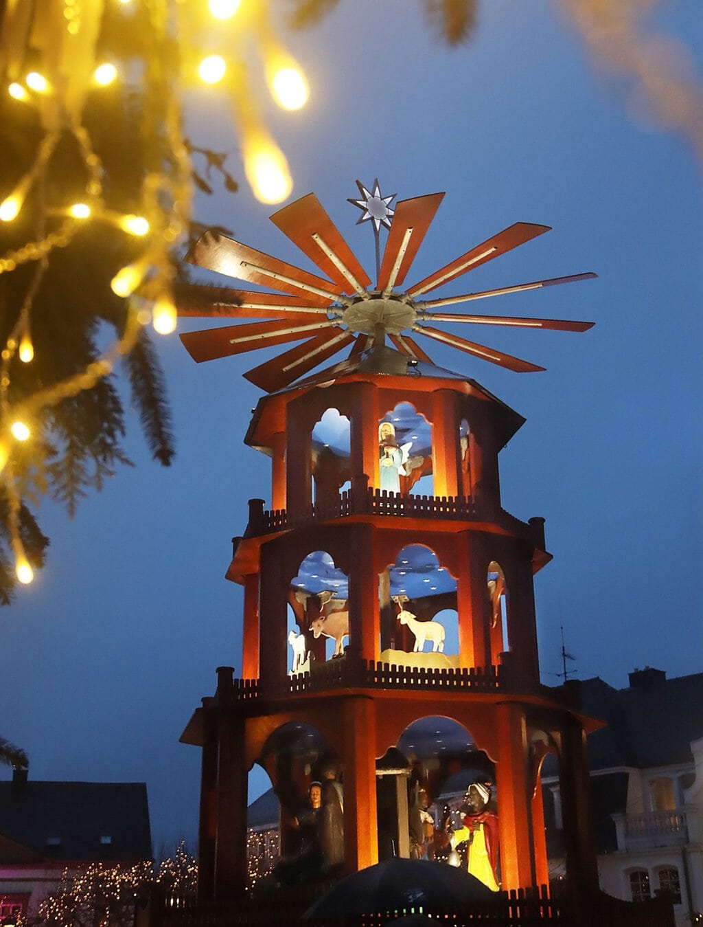 Verlichte houten kerstpiramide met kerstfiguren in het blauwe avondlicht op de kerstmarkt van St. Wendel