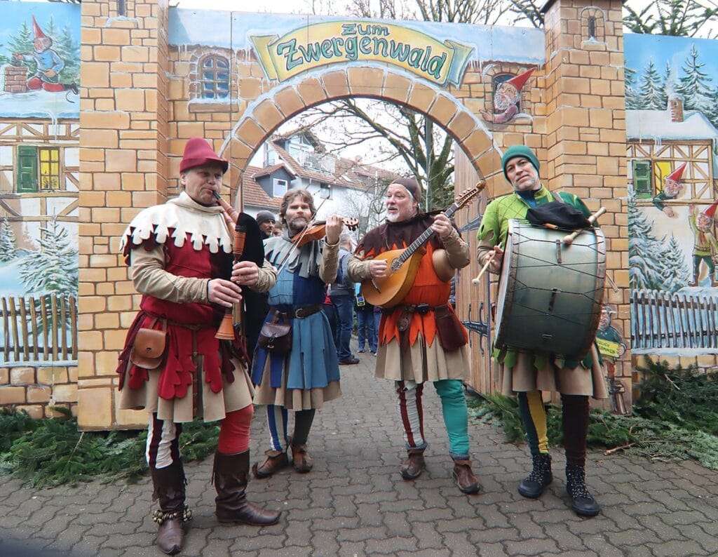 Vier middeleeuwse muzikanten met doedelzak, viool, luit en trom voor de poort van het Zwergenwald in St. Wendel